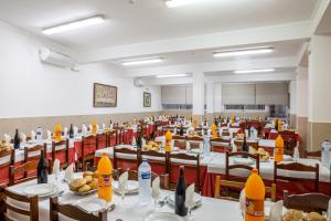 a large room with tables and chairs with food on them at Hotel Nossa Senhora da Paz in Fátima