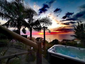 a bath tub with a view of a sunset at Dazkarizeh73 in Ribeira Brava