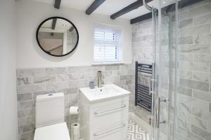 uma casa de banho com um WC, um lavatório e um espelho. em Host & Stay - Burns Yard Apartment em Whitby