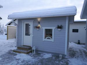 a small house with snow on the side of it at Cozy Cottage - Free WIFI and Parking in Rovaniemi