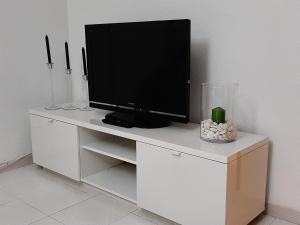 a tv sitting on top of a white cabinet at family apartment near of beach in Benidorm