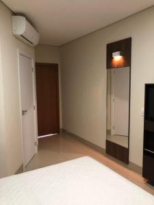 an empty room with a bed and a mirror at Hotel Bem Bom in Campo Verde