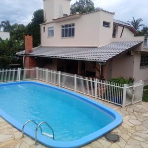 une grande piscine bleue en face d'une maison dans l'établissement POUSADA LOS AMIGOS CAMPECHE, à Florianópolis