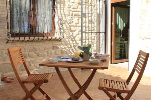 una mesa de madera y 2 sillas en el patio en A Casa Nostra Residenza di Charme - Struttura sanificata giornalmente con ozono, en Candela