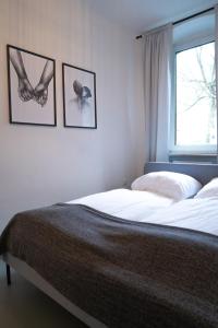ein Schlafzimmer mit einem Bett mit zwei Bildern an der Wand in der Unterkunft Gemütliches Appartment südlich vom Wöhrder See in Nürnberg