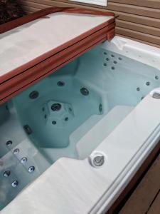 a jacuzzi tub in a wooden deck at Strong Timbers BnB in Kingsclear