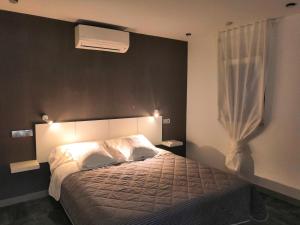um quarto com uma cama com um edredão branco e uma janela em ASV Apartments em Pineda de Mar