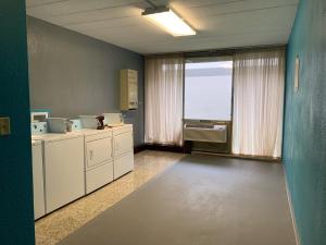 a kitchen with white cabinets and a large window at FairBridge Inn Express Melrose Park in Melrose Park