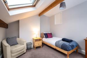 a bedroom with a bed and a chair at Bedzzz - Booklovers Dream in Preston