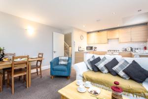 a living room and kitchen with a couch and a table at Bedzzz - Booklovers Dream in Preston