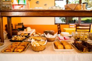 uma mesa com muitos tipos diferentes de doces sobre ele em Pousada Doce Rio em Três Marias