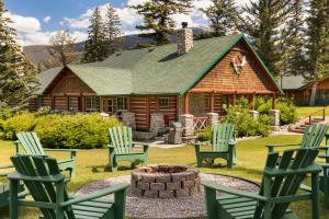 a log cabin with rocking chairs in front of it at Fairmont Jasper Park Lodge in Jasper