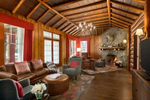 a living room with leather furniture and a stone fireplace at Fairmont Jasper Park Lodge in Jasper