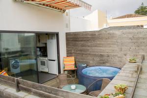 a patio with a hot tub and a table and chairs at Marketplace Apartment 1 in Ponta Delgada