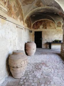 due grandi vasi seduti accanto a un muro di Il Chiostro di Paolo a Corciano