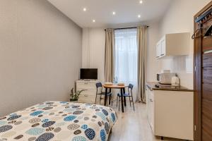een slaapkamer met een bed en een keuken met een tafel bij KATO Apartamenty Moniuszki in Katowice