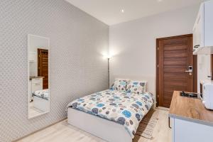 a small bedroom with a bed and a mirror at KATO Apartamenty Moniuszki in Katowice