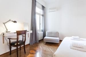 a bedroom with a desk and a bed and a chair at Athens Heritage Suite in Athens