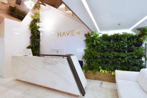 a lobby with a green wall and a white couch at Haven A Design Hotel in Medellín
