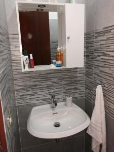ein Badezimmer mit einem weißen Waschbecken und einem Spiegel in der Unterkunft Casa Sunshine - Casa Vacanze al mare in Punta Braccetto
