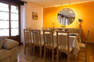 a dining room with a table and chairs and a mirror at Cortea I y II in Añézcar