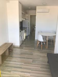 Una sala de estar con una mesa y una cocina. en Ático Port La Ràpita, en Sant Carles de la Ràpita