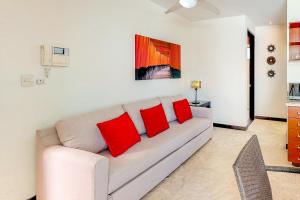 sala de estar con sofá y 2 almohadas rojas en Klem Residence, en Playa del Carmen