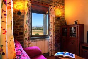 a living room with a couch and a window at Casas Pirineo, Ainsa in Aínsa