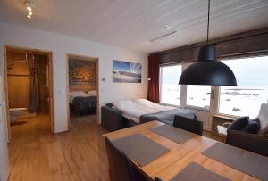 1 dormitorio y sala de estar con mesa de comedor. en The Potato Storage, en Svínafell