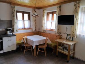 cocina con mesa y sillas y TV en Ferienwohnung Peintnerhof en Innervillgraten