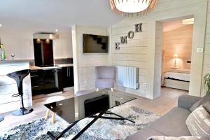 een woonkamer met een bank en een tafel bij Chalet cosy de Plage entre Biarritz et Hossegor in Tarnos