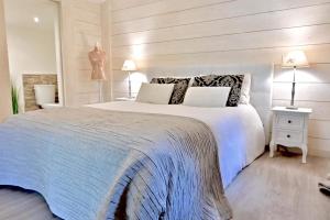 a bedroom with a large white bed and two lamps at Chalet cosy de Plage entre Biarritz et Hossegor in Tarnos