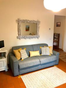 蒙塔约内2-BR 1 bath abode with 2 AC units in the Chianti hills!的客厅配有蓝色沙发,设有镜子