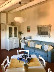 蒙塔约内2-BR 1 bath abode with 2 AC units in the Chianti hills!的客厅里有一张蓝色的沙发和一张桌子