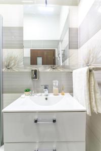 a white bathroom with a sink and a mirror at Apartment Queen in Sibiu +51 photos