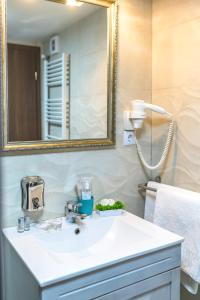 a bathroom with a white sink and a mirror at Apartment Queen Bridge in Sibiu +110 photos