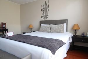 a bedroom with a large white bed and two lamps at Embassy Quito in Quito