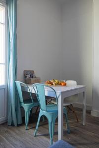 een tafel met twee stoelen en een tafel met fruit erop bij Le Panoramique Salonais in Salon-de-Provence