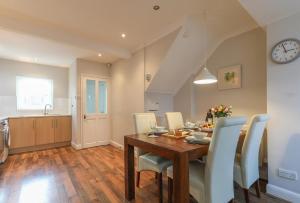 a kitchen and dining room with a table and chairs at Bedzzz - House on the Green in Preston