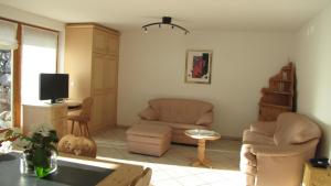 ein Wohnzimmer mit 2 Stühlen und einem TV in der Unterkunft Chesa Ovelin in Pontresina