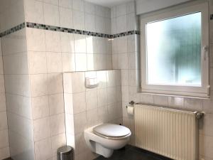 a white bathroom with a toilet and a window at Ferienhaus an der Bäderstraße in Pohl +51 photos