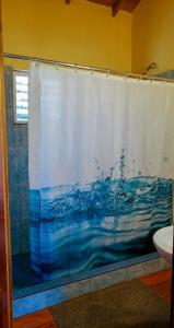 a shower in a bathroom with a shower curtain at The Tranquila Caye- Gold Standard Certified in Caye Caulker