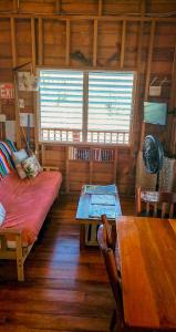 a room with a bed and a table in a cabin at The Tranquila Caye- Gold Standard Certified in Caye Caulker