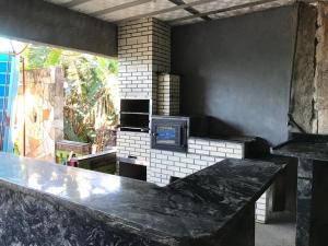 a kitchen with a stone counter and a stove at CHACARA RECANTO PARAISO in Jarinu