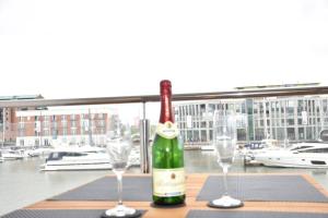 a bottle of wine sitting on a table with two glasses at LOFT Port Marina 26 in Bremerhaven