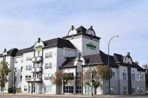 ein großes weißes Gebäude mit schwarzem Dach in der Unterkunft Wingate by Wyndham Lethbridge in Lethbridge