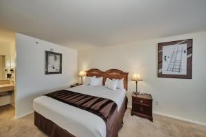 a hotel room with a large bed and a nightstand at Adventure Inn Durango in Durango