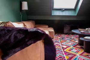 a living room with a leather couch and a rug at Prestigieux Appartement Pied Piste Luc Alphand 80 M2 Serre Chevalier Chantemerle in Saint-Chaffrey