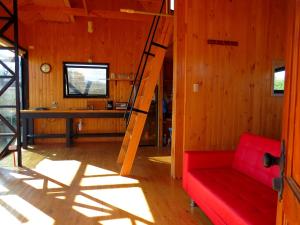 sala de estar con sofá rojo y escalera en Encantador Loft, entre Viñas, Valles y Piscina Privada, en Santa Cruz