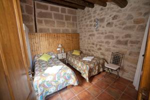 Camera piccola con 2 letti e una sedia di Casas Rural Calaceite a Calaceite
